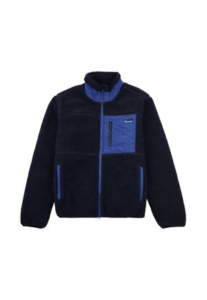 Chaqueta de forro polar en azul marino con un bolsillo en el pecho con cremallera de color azul claro en contraste, dos bolsillos frontales, cuello alto y textura suave.