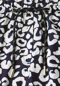 Pantaloni corti blu navy con stampa leopardata bianca e azzurro chiaro, caratterizzati da un cordoncino nero con hardware argentato e una vita testurizzata.