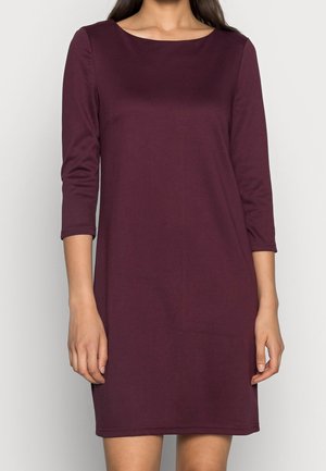 Robe bordeaux en tissu doux, présente un col rond, des manches trois-quarts et une silhouette ajustée avec des détails de couture minimaux.