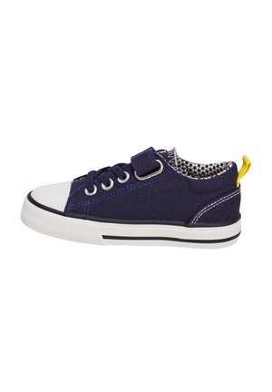 Baskets en toile marine avec un bout et une semelle en caoutchouc blanc, une semelle rayée noire et blanche contrastante, et une boucle au talon jaune. Sangle velcro ajustable.