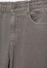 Gray cotton trousers with an elastic waistband, button closure, front pocket, and a textured fabric finish.