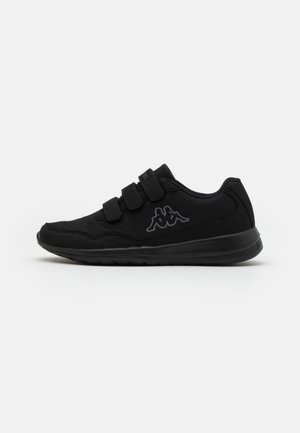 Chaussure de sport noire avec trois sangles à crochets et boucles et un logo gris représentant deux figures assises sur le côté.