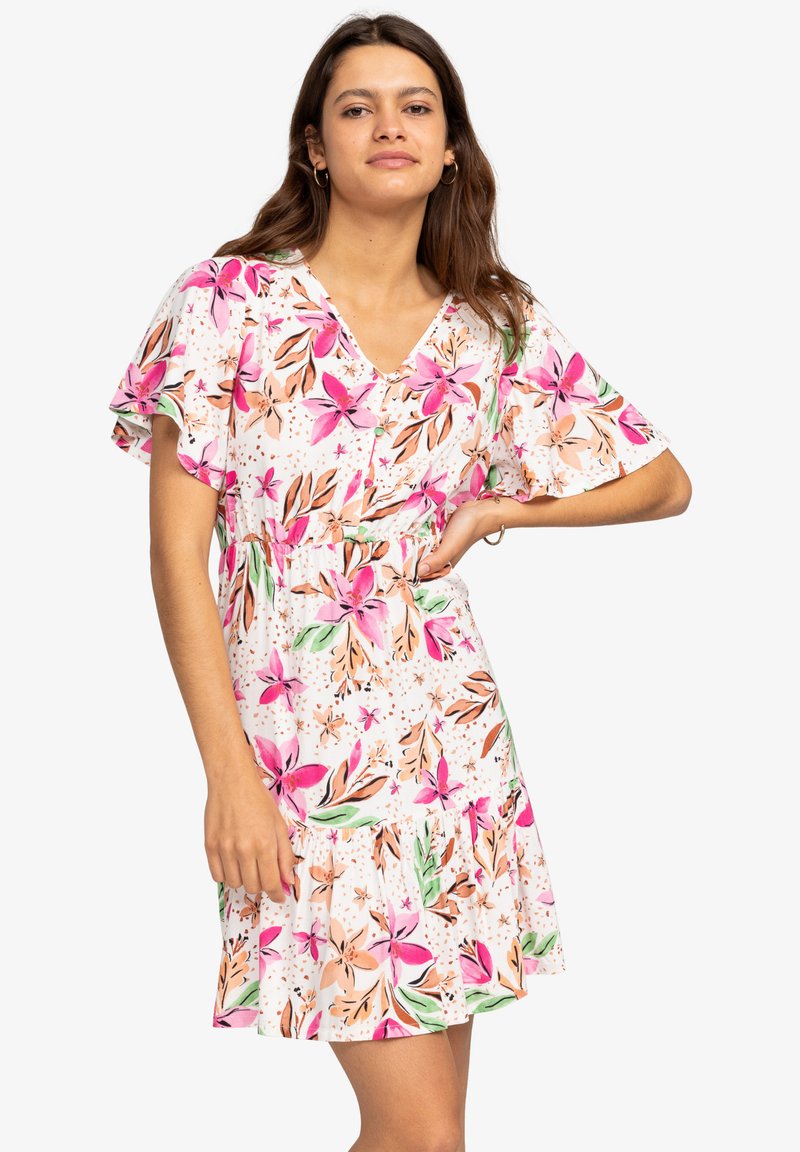 Bloemige jurk met een witte achtergrond en roze en perzikbloemen, korte gerimpelde mouwen, een V-hals en een uitlopende zoom.