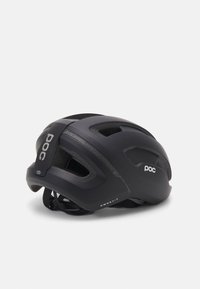 Casco da ciclismo nero con design aerodinamico, multiple aperture di ventilazione, superficie testurizzata e un logo prominente sulla parte anteriore.
