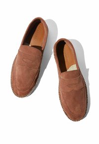 Smeđi suede loaferi s gornjim dijelom sa šavovima, bočnim detaljima i izdržljivom potplatom s pletenim rubom. Obloženi mekim kožom.