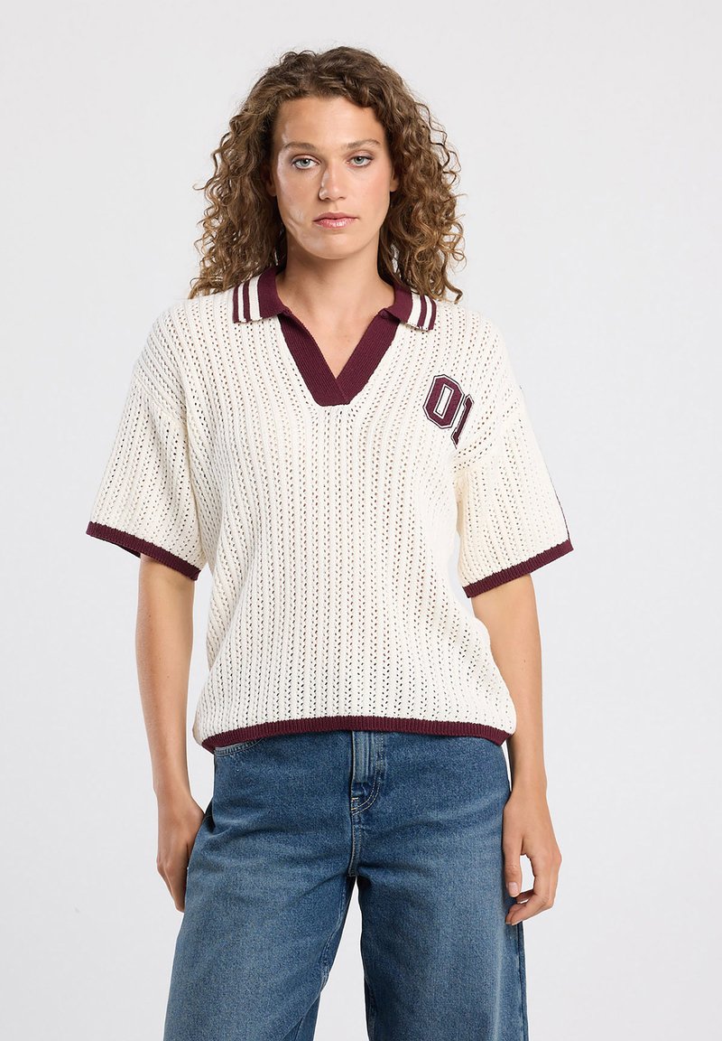Knit polo-style top in cream with burgundy accents, featuring a v-neck, short sleeves, and a sporty embroidered '01' detail.