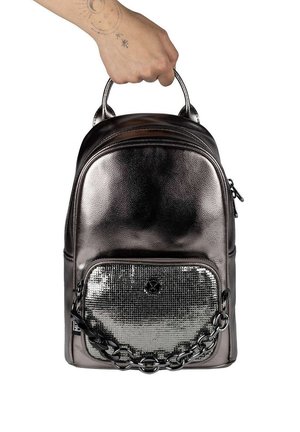 Mochila plateada metálica con un acabado texturizado. Cuenta con un bolsillo frontal con un detalle tipo malla y un acento de cadena. Incluye dos asas superiores.
