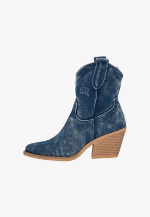 Denim enkellaarsjes met een puntige neus, gestapelde houten hak, vintage wassingen en subtiele stiksels aan de zijkanten.