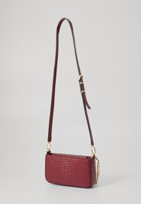 Burgundy handbag with a textured, faux-crocodile skin finish. Features a gold chain accent and a detachable shoulder strap.