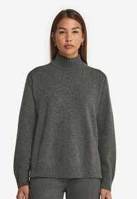 Dunkelgrauer Rollkragenpullover mit geripptem Ausschnitt und Bündchen. Weicher, strukturierter Stoff mit lässiger Passform. Gerade Saumlinie.