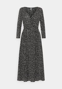 Czarna sukienka z długim rękawem i dekoltem w serek, z białym abstrakcyjnym wzorem, talią podkreśloną w pasie i zwiewnym dołem. Miękka faktura materiału.