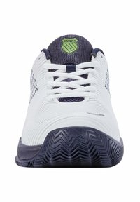 Scarpa sportiva bianca con una tomaia testurizzata, dettagli blu navy e suola in gomma spessa con motivo a zigzag. Logo K-Swiss sulla linguetta.