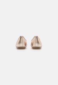 Metalliske roser lær slip-on sko med rund tå, flat såle og subtile stingdetaljer langs baksemen.