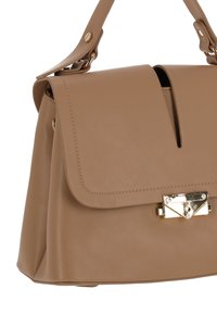 Brunläderhandväska med klaffstängning och guldfärgad metall. Har en utskuren detalj framtill och en strukturerad form.