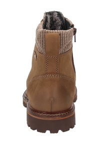Braune Leder-Stiefelette mit einem gerippten Textilkragen, gepolstertem Innenraum, seitlichem Reißverschluss und robustem Gummisohle für einen guten Halt.