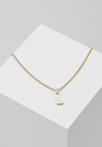 Halskette in Goldfarbe mit einer Kette und einem einfachen, L-förmigen Anhänger; elegantes Design, glatte Oberfläche und minimalistischer Stil.