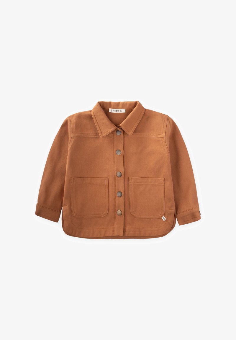 Pruun, nööbidest särk, mis on valmistatud tekstuuriga kangast ja millel on kaks esi-taskut ning klassikaline krae. Ümar alläär ja pikad varrukad.