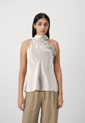 Lys beige ermeløs topp med høy volangkrage, med en glatt satengtekstur og asymmetrisk design på den ene siden.