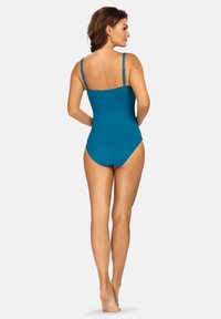 Turkusowy jednoczęściowy strój kąpielowy z regulowanymi ramiączkami, gładką teksturą i dopasowanym krojem, wyróżniający się prostym, jednolitym kolorem.