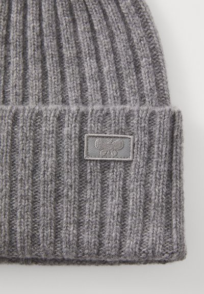 Gray knitted beanie with a ribbed texture, featuring a folded cuff and a small gray fabric tag with an embroidered logo.