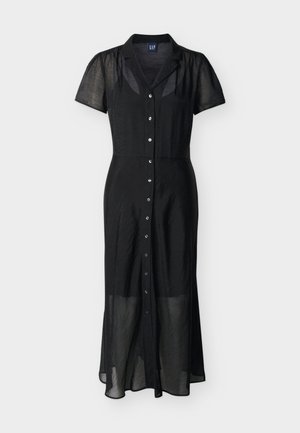 Robe mi-longue noire en tissu transparent avec manches courtes bouffantes, devant à boutons, et col cranté, présentée sur un fond blanc.