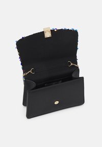 Svart handväska med flerfärgade paljetter på klaffen, gyllene spärr, kedjeaxelrem och öppen insida som visar fack mot vit bakgrund.