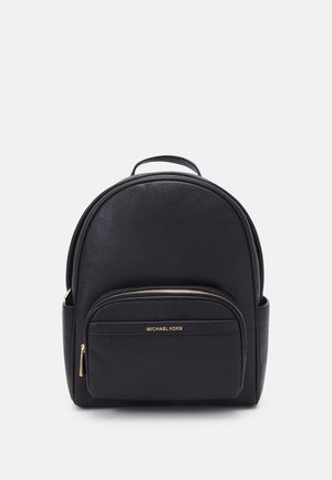Schwarzer Leder-Rucksack von Michael Kors mit vorderer Reißverschlusstasche, oberem Griff und Seitentaschen auf einfarbig hellem Hintergrund.