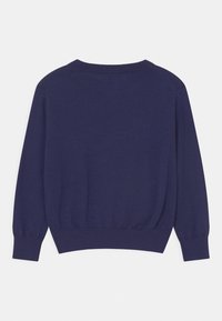 Tmavě modrý pletený svetr s dlouhými rukávy, hladkým kulatým výstřihem a manžetami. Spodní lem je vzadu mírně delší. Hladká textura.