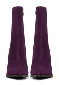 Botines de ante púrpura con punta afilada, que presentan una textura suave, tacón alto y detalles de costura a lo largo de los lados.