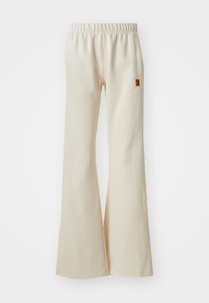 Pantaloni bej, evazați, dintr-un material moale, cu talie elastică și buzunar lateral. Prezintă o mică etichetă cu logo pe șold.