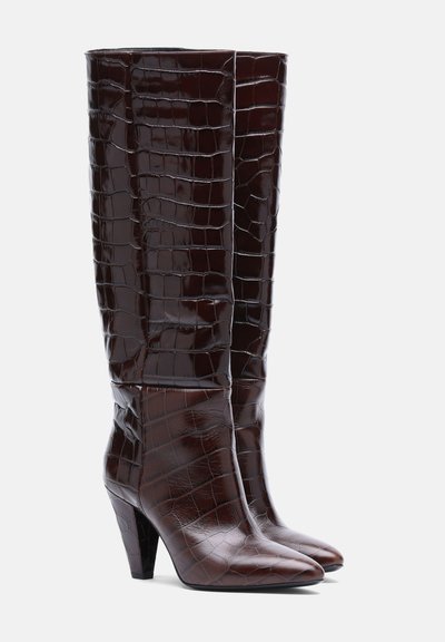 Paire de bottes hautes en cuir marron foncé avec un motif crocodile et des bouts pointus sur talons blocs moyens.