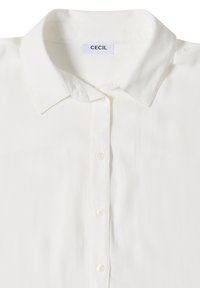 Chemise blanche à boutons avec col classique et étiquette de marque "CECIL" à l'intérieur de l'encolure.