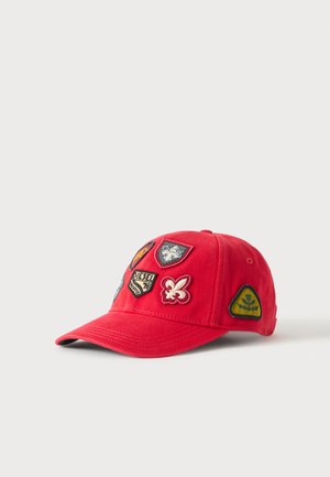 Casquette de baseball rouge décorée de cinq écussons brodés colorés à l’avant et sur le côté, comprenant des motifs floraux et de blason.