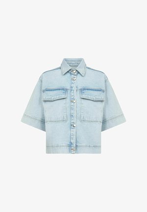 Light blue denim shirt with short sleeves, two front pockets, and silver snap buttons. Has a classic collar and a slightly oversized fit.