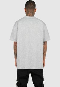 Grå kortærmet t-shirt, lavet af blødt stof, har en afslappet pasform med rund halsudskæring. Bagen viser et enkelt design uden logoer.