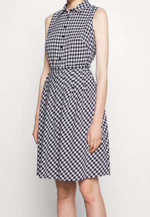 Bezrekawowa czarno-biała sukienka w kratę gingham z guziczkami z przodu, kołnierzykiem, dopasowaną talią i spódnicą o długości do kolan w kształcie litery A.