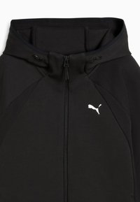 Hoodie zippé noir avec col montant, présentant des panneaux latéraux texturés et un logo Puma blanc sur la poitrine. Finition en tissu lisse.