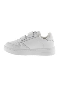 Zapatilla blanca que presenta un exterior de cuero suave, caja de puntera perforada, correas dobles de gancho y bucle, y una suela de goma plana.