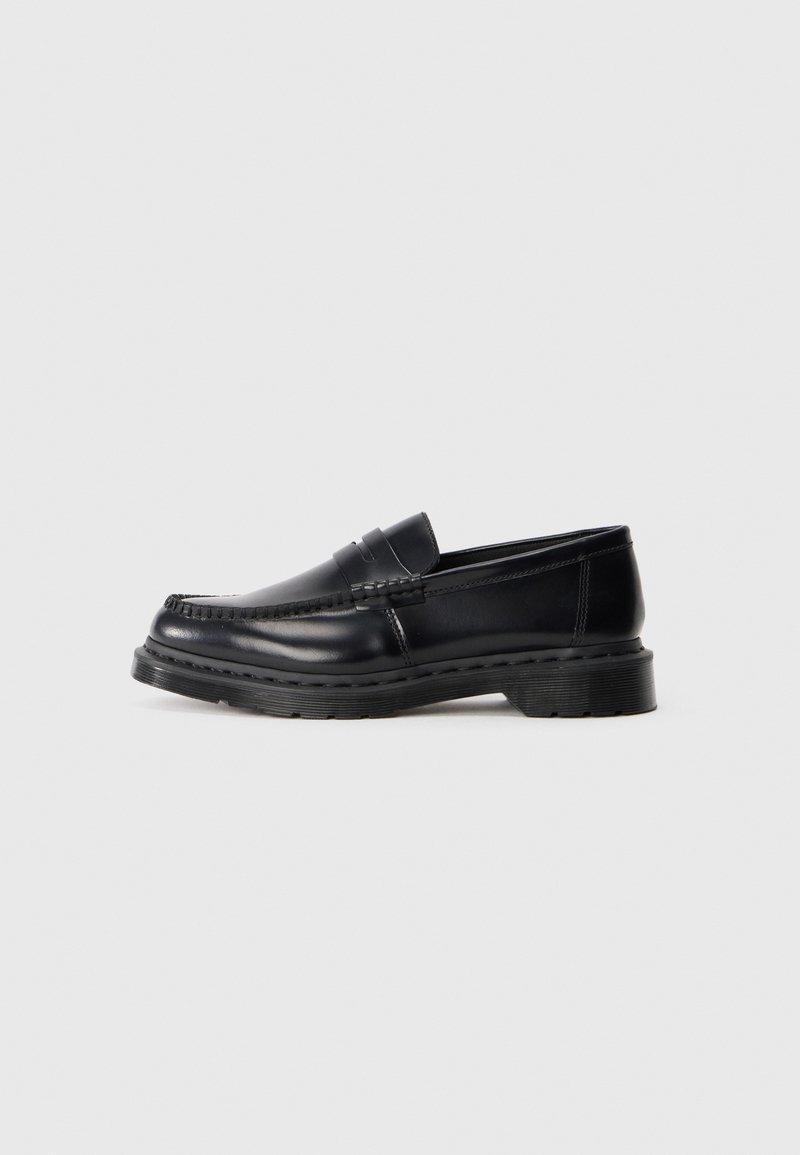 Sapato masculino de couro preto estilo penny loafer com sola grossa e costura moc toe, apresentado em perfil sobre fundo branco.