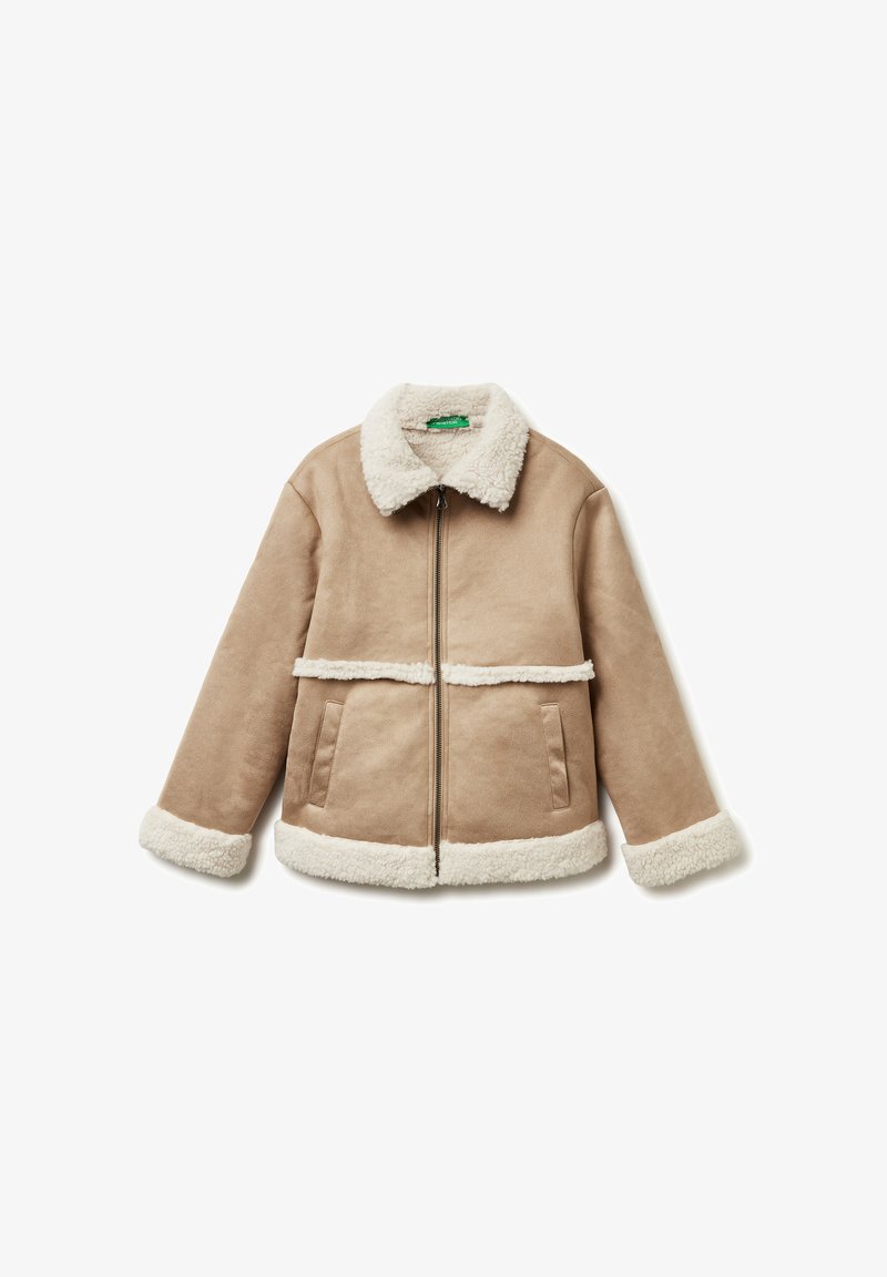 Giacca shearling color sabbia con chiusura a zip, colletto e polsini morbidi bianchi, con due tasche laterali e una cucitura orizzontale foderata in pelliccia.