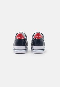 Navy leather sneakers with white midsole, red accents on the heel, and striped detailing on the sole. Smooth finish with rounded shape.