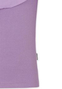 T-shirt lilla a coste con una sovrapposizione liscia sulla spalla. Include un piccolo etichetta sulla cucitura laterale. Il tessuto appare morbido ed elasticizzato.