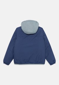 Veste bleu marine avec une capuche bleu clair, des poignets et une taille élastiques. Texture lisse avec un design simple, vue de dos affichée.