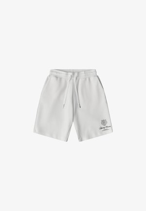 Pantalones cortos casuales blancos con cintura ajustable mediante cordón, bolsillos laterales y pequeño logo negro junto con texto en la parte inferior de la pierna izquierda.