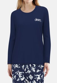 Marineblaues Langarmshirt aus weichem Stoff, mit Rundhalsausschnitt und dem Wort "dream." in Weiß auf der Vorderseite gestickt.