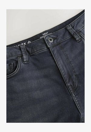 Jean en denim foncé avec une texture lisse, une conception classique à cinq poches, et une fermeture à boutons sur le devant avec des détails de surpiqûres contrastées.