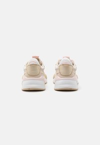 Sneaker beige e bianche con dettagli rosa, dotate di un pannello posteriore testurizzato, collo imbottito e un design della suola robusto.