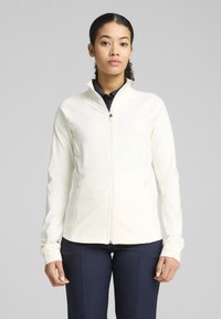 Veste zippée légère de couleur crème avec une coupe ajustée, texture douce et col montant. Comprend des poches latérales et des poignets texturés.