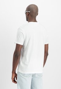 Hvid bomulds t-shirt med rund hals, korte ærmer og en afslappet pasform. Har diskret syninger og et ensartet design.