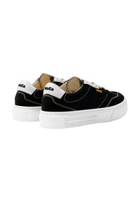 Fekete vászon sneaker fehér részletekkel, kerek orral és masszív fehér gumitalppal. Jellemzői közé tartozik a varrás részletezők és egy logó a hátsó részen.